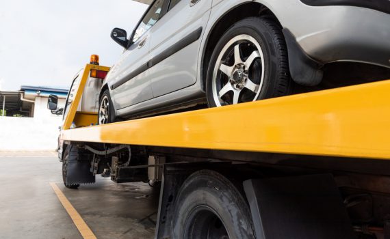 broken car on flatbed tow truck being transported UA2Y3P5